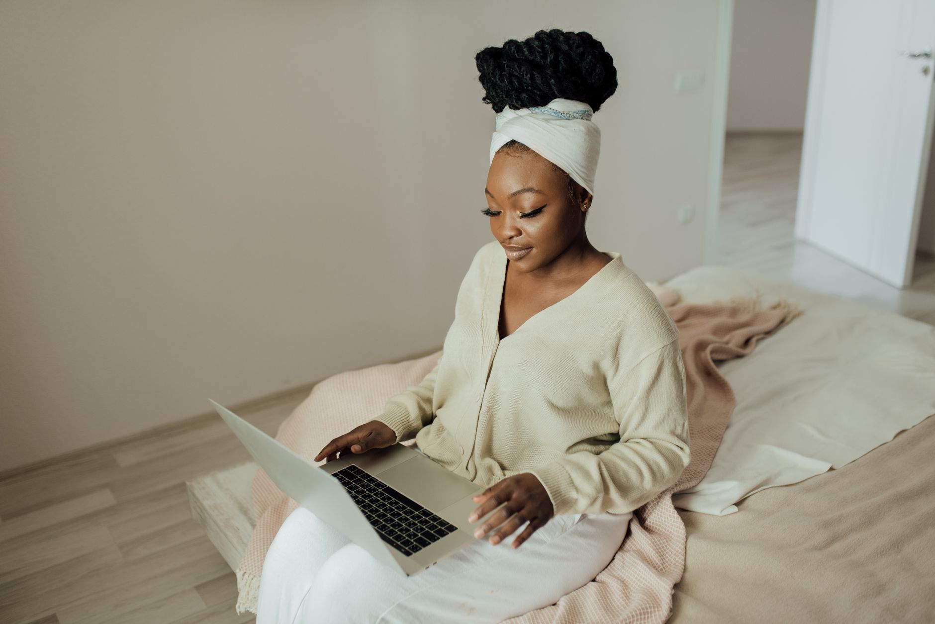 lady working on her laptop wearing beige and white clothing